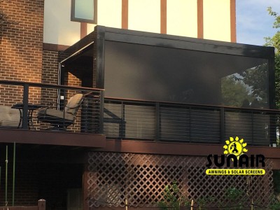 A black retractable awning over patio area
